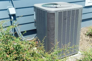 Outdoor air conditioning unit beside a home, showing one of the common signs your air conditioning needs servicing.