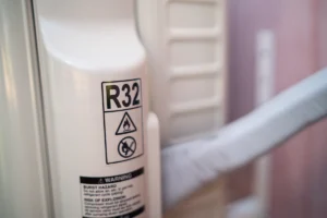 R32 refrigerant label on an outdoor AC unit, showing a close-up of r32 refrigerant safety markings on modern HVAC equipment
